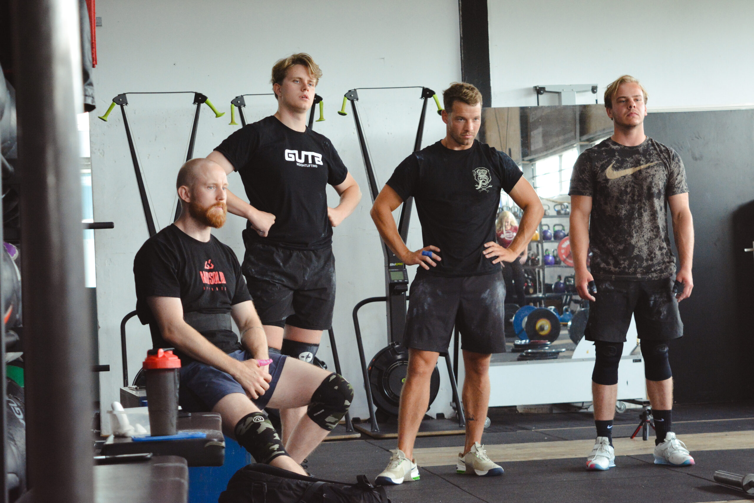 Mannen die bij crossfit staan te rusten en kijken